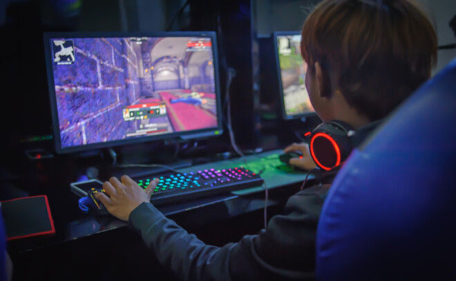 Gutt spiller dataspill i mørket
